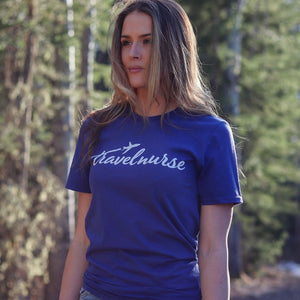 model wearing a blue travel nurse shirt with a white logo
