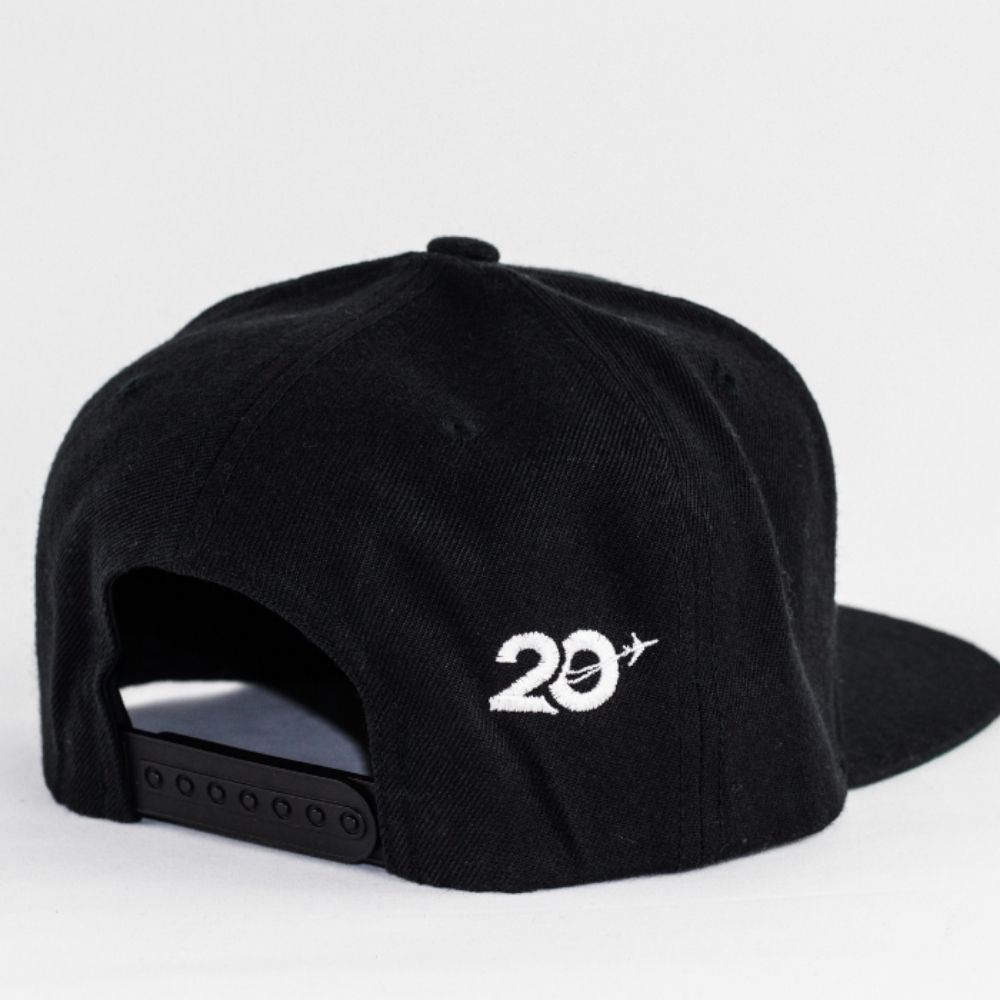 Product photo showing a black snapback with a white 20th anniversary logo for travel nurse canada