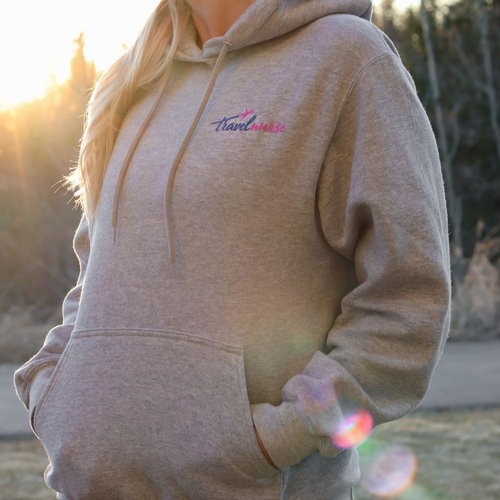 Sweatshirt with a kangaroo pocket and a travel nurse logo in pink and blue